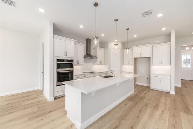 1929 NW 85th Loop, Ocala, FL 34475 - kitchen featuring wall chimney exhaust hood, stainless steel double oven, light wood finished floors, white cabinets, and recessed lighting