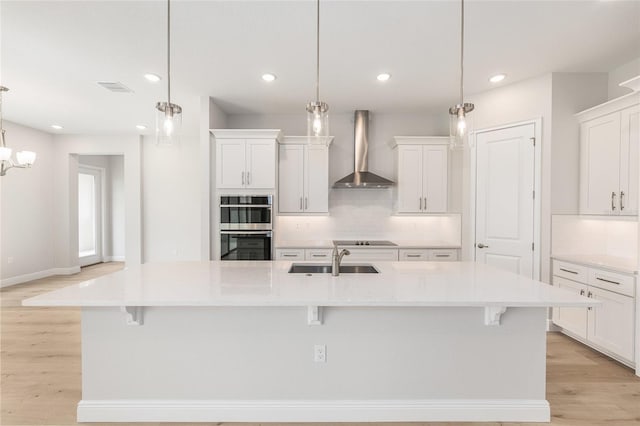 1929 NW 85th Loop, Ocala, FL 34475 - kitchen featuring wall chimney range hood, stainless steel double oven, black electric cooktop, tasteful backsplash, and white cabinetry