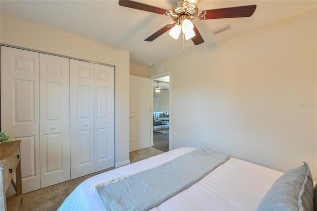 bedroom featuring light colored carpet, a closet, visible vents, and ceiling fan