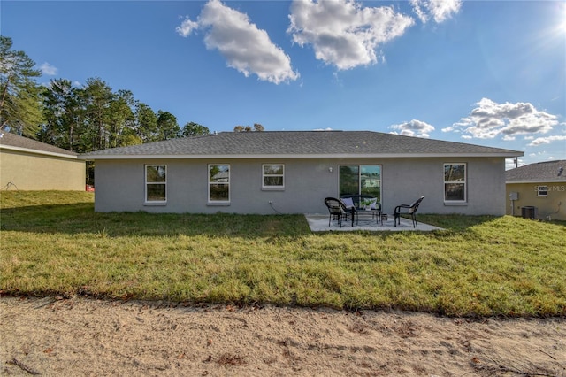 back of house featuring a lawn, a patio area, stucco siding, and central air condition unit