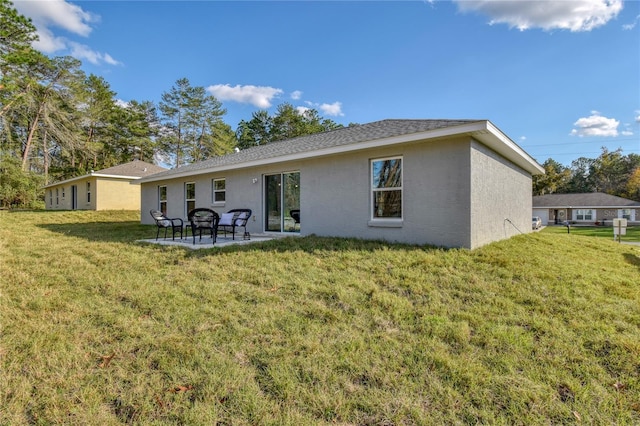 back of house featuring a patio, a lawn, and stucco siding