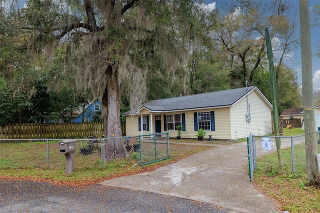 ranch-style home with driveway and a fenced front yard