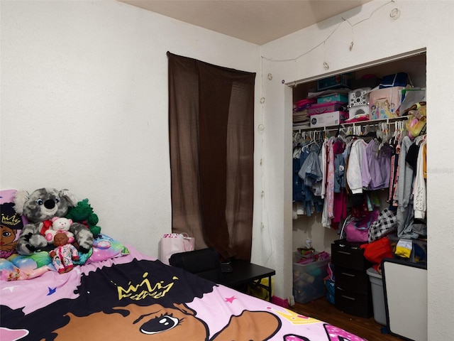 bedroom featuring dark wood-style flooring and a closet