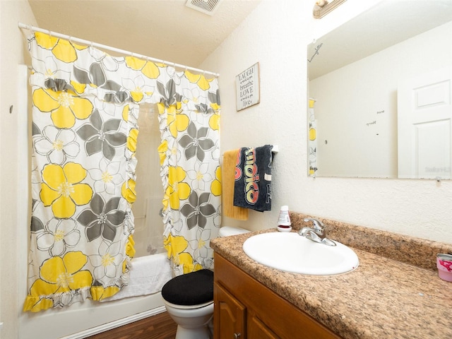 bathroom featuring toilet, visible vents, shower / bath combination with curtain, and vanity