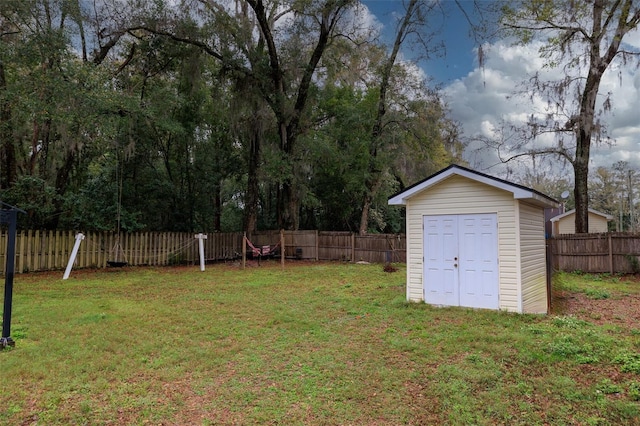 view of yard featuring a fenced backyard, an outdoor structure, and a shed