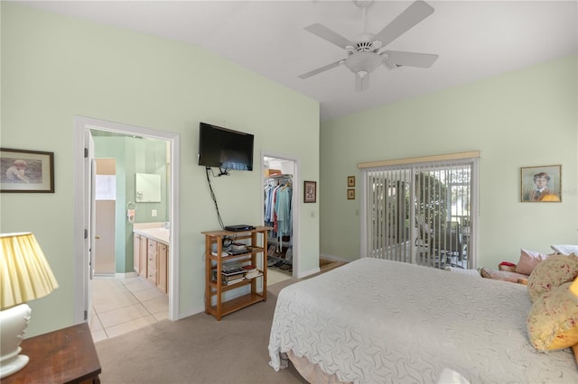 bedroom with light colored carpet, a spacious closet, vaulted ceiling, ensuite bath, and access to outside