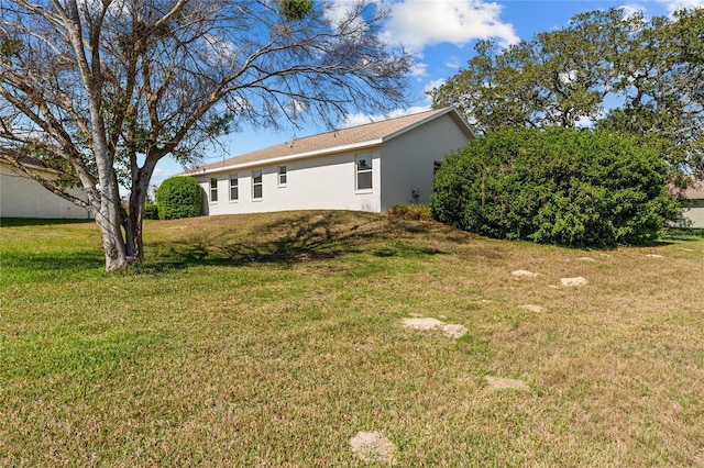 view of home's exterior with a yard and stucco siding