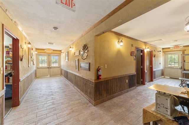 hallway with french doors and wainscoting