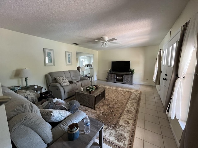 living area with light tile patterned floors, a textured ceiling, visible vents, and a ceiling fan