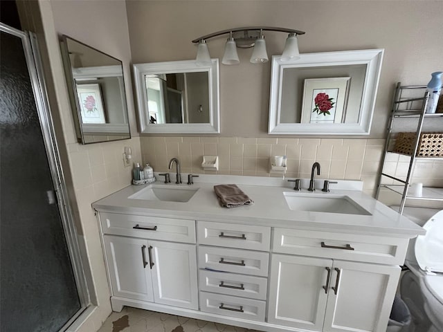 full bath with double vanity, a shower stall, toilet, and a sink