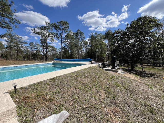 view of pool featuring a covered pool and a yard