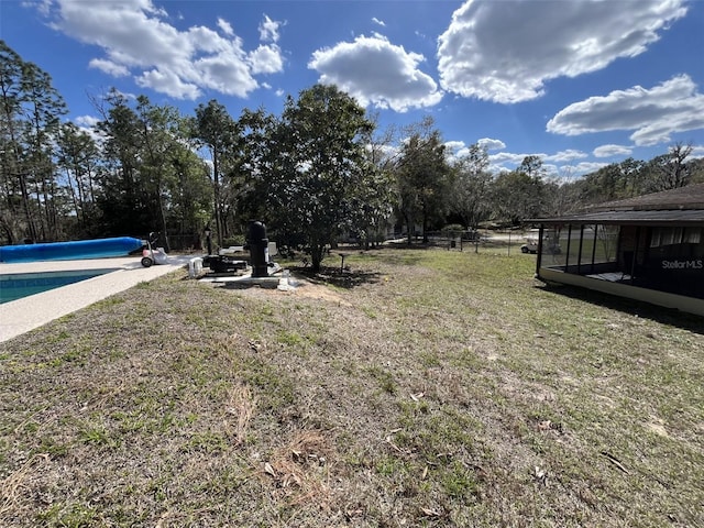 view of yard with fence and a covered pool