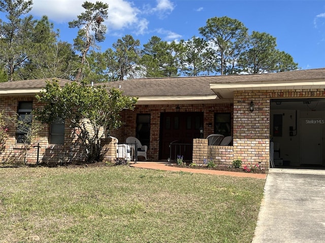 view of front of property with roof with shingles, brick siding, a front lawn, and an attached garage