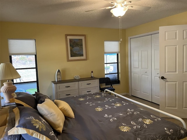 bedroom featuring a closet, multiple windows, ceiling fan, and a textured ceiling