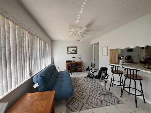 living room with light tile patterned floors, a textured ceiling, and a ceiling fan