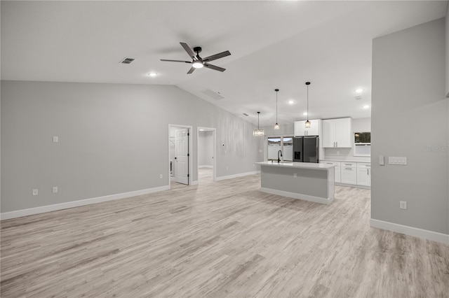 unfurnished living room featuring baseboards, visible vents, a ceiling fan, lofted ceiling, and light wood-style floors