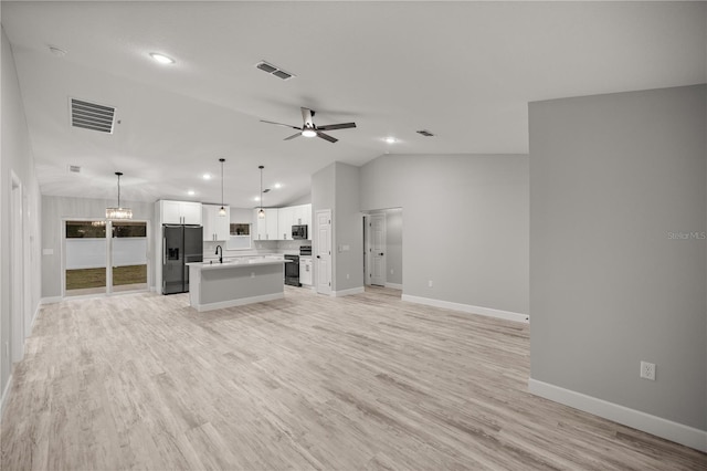 unfurnished living room with visible vents, a sink, light wood-style flooring, and ceiling fan with notable chandelier