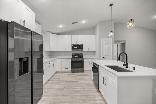 kitchen featuring white cabinetry, stainless steel appliances, a sink, and light countertops