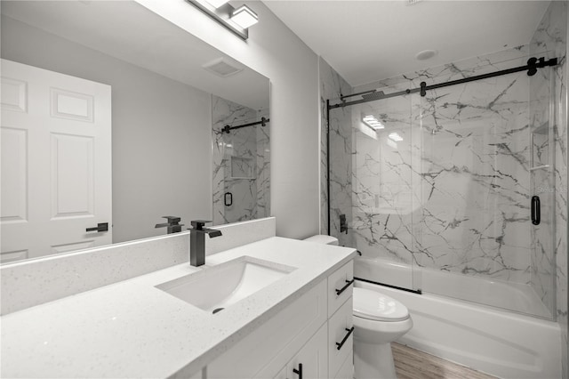 full bathroom featuring toilet, shower / bath combination with glass door, wood finished floors, and vanity