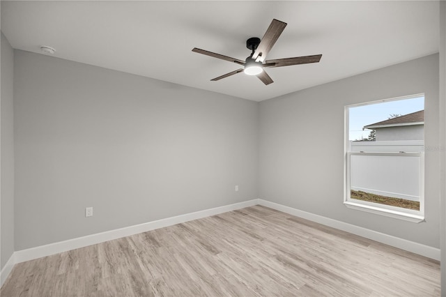 empty room featuring light wood finished floors, plenty of natural light, and baseboards