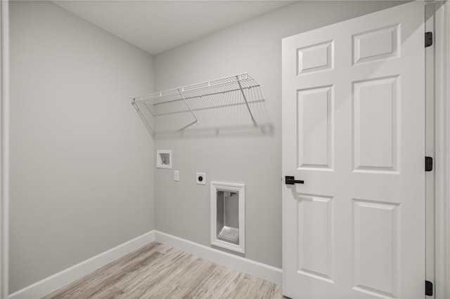 clothes washing area with washer hookup, electric dryer hookup, light wood-type flooring, laundry area, and baseboards