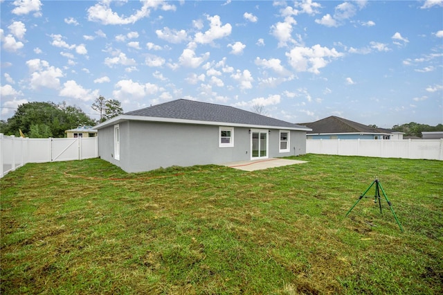 rear view of property with a yard, a patio area, a fenced backyard, and stucco siding