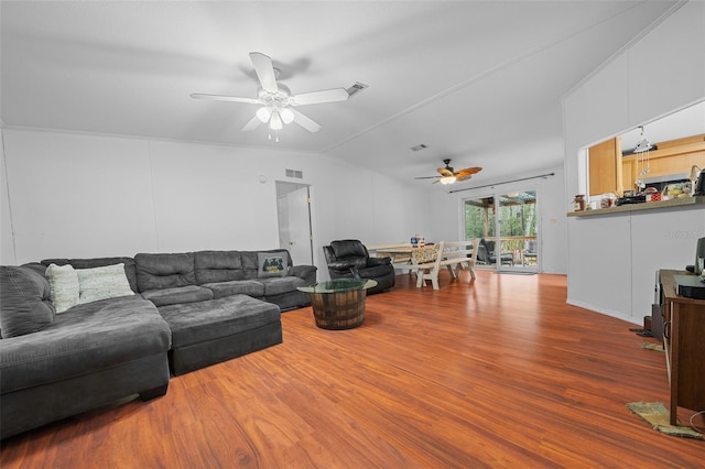 living room featuring a ceiling fan, lofted ceiling, visible vents, and wood finished floors