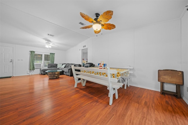 dining room with a ceiling fan, lofted ceiling, visible vents, and wood finished floors