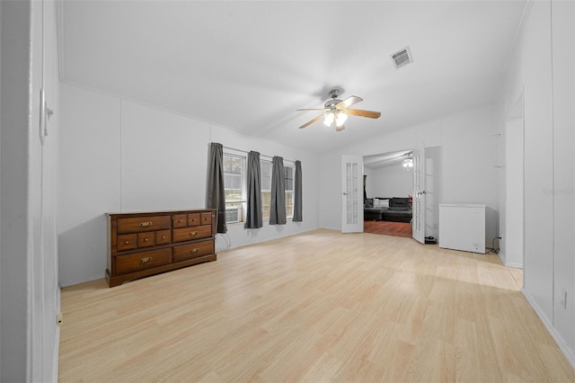 interior space with visible vents, vaulted ceiling, light wood finished floors, and ceiling fan