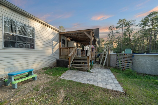 view of yard with stairway, an outdoor pool, and a patio