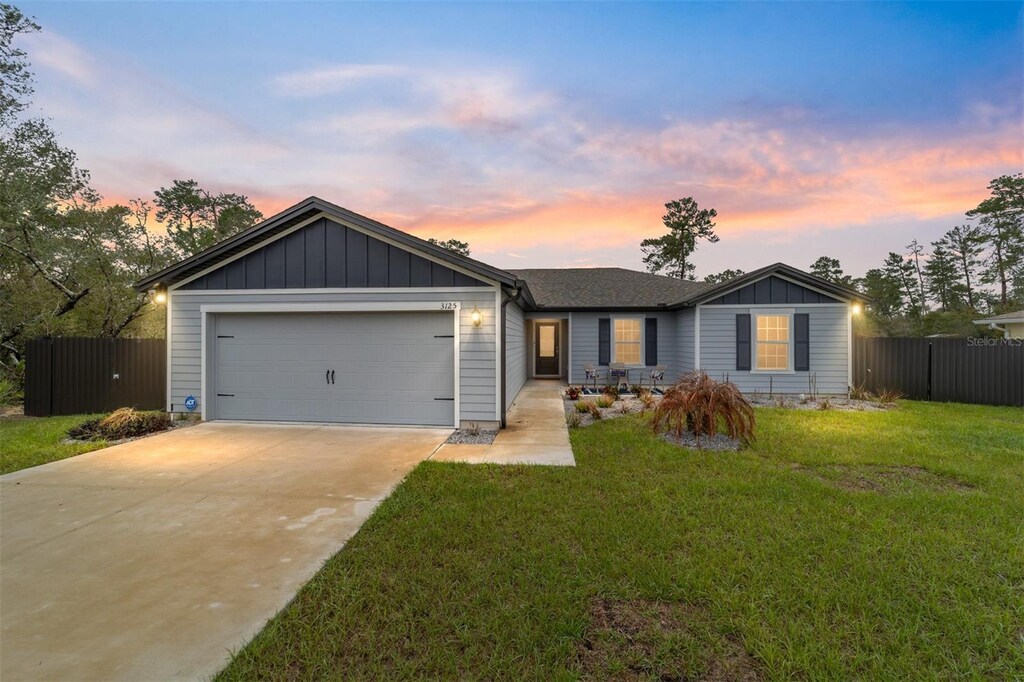 3125 SW 172nd Lane Rd, Ocala, FL 34473 - single story home featuring driveway, board and batten siding, an attached garage, and fence