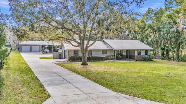 1010 SW 26th St, Ocala, FL 34471 - ranch-style house with a garage, metal roof, a front yard, and an outdoor structure