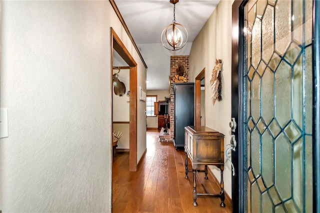 foyer entrance featuring a notable chandelier, baseboards, and hardwood / wood-style floors