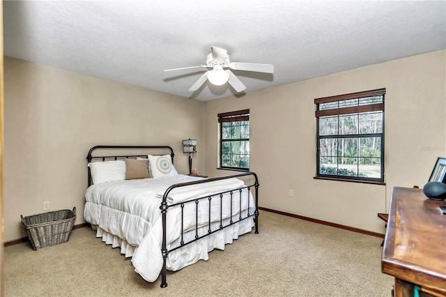 bedroom featuring carpet floors, ceiling fan, baseboards, and a textured ceiling