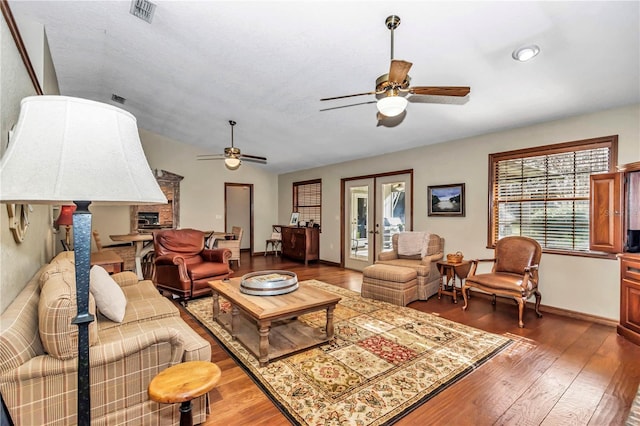 living area featuring wood-type flooring, visible vents, and ceiling fan