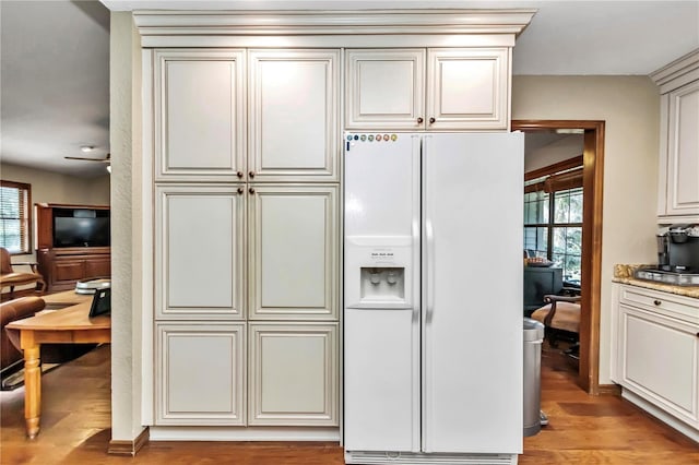 kitchen featuring light wood finished floors, plenty of natural light, and white refrigerator with ice dispenser