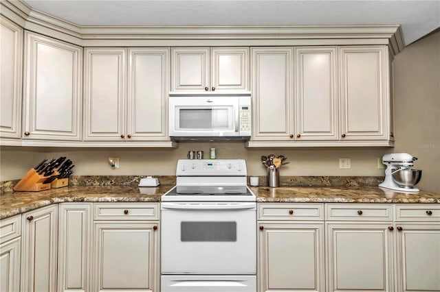 kitchen with stone countertops, white appliances, and cream cabinetry