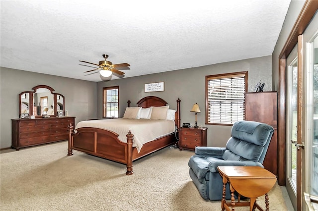 carpeted bedroom with ceiling fan and a textured ceiling