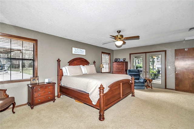 bedroom with carpet floors, access to exterior, a textured ceiling, and french doors