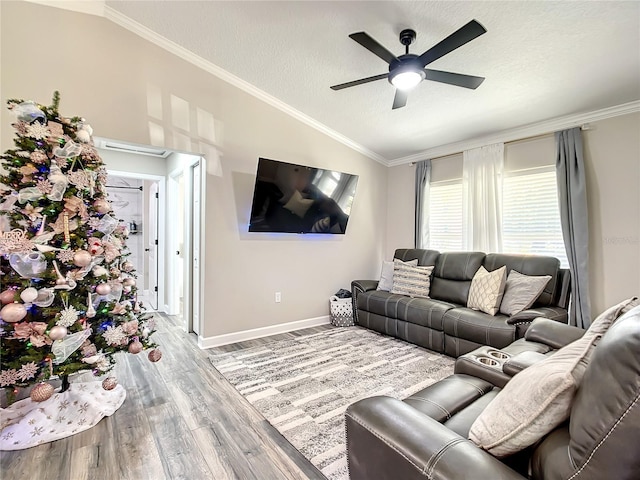 living area with light wood-style floors, a textured ceiling, vaulted ceiling, and crown molding