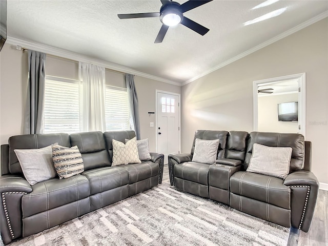 living room with light wood-type flooring, ornamental molding, vaulted ceiling, and a ceiling fan