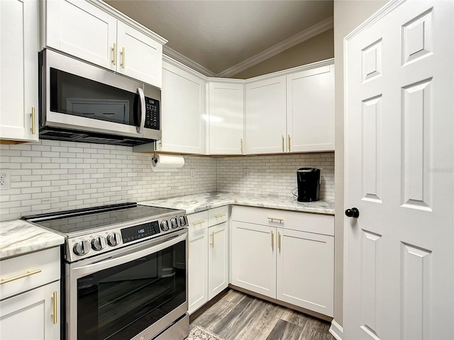 kitchen with light stone countertops, white cabinetry, appliances with stainless steel finishes, and ornamental molding