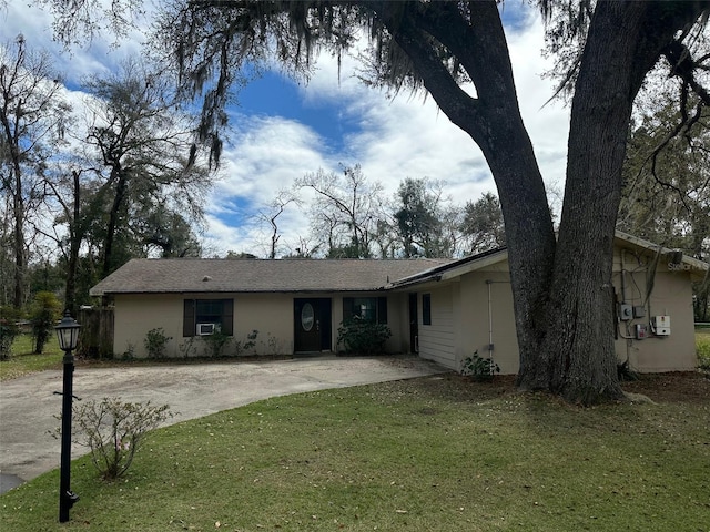 ranch-style home with driveway and a front yard