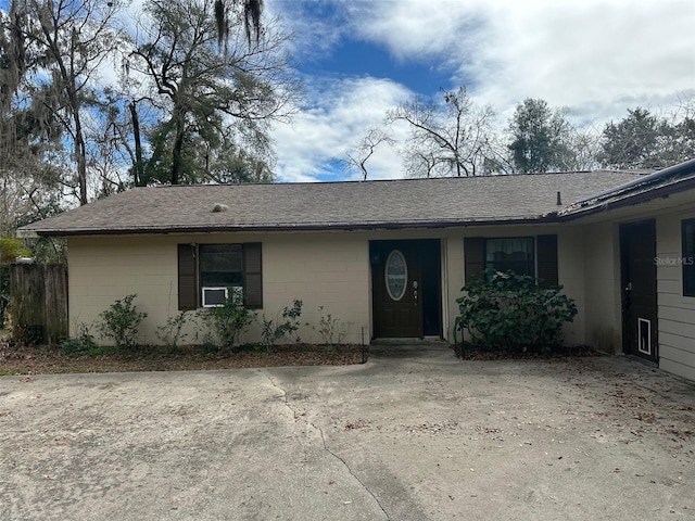 single story home with concrete block siding and roof with shingles