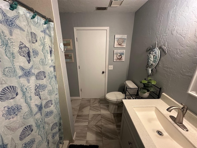 bathroom featuring visible vents, a textured wall, a stall shower, and vanity