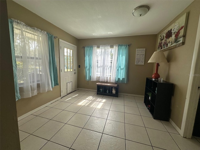 foyer featuring light tile patterned floors and baseboards