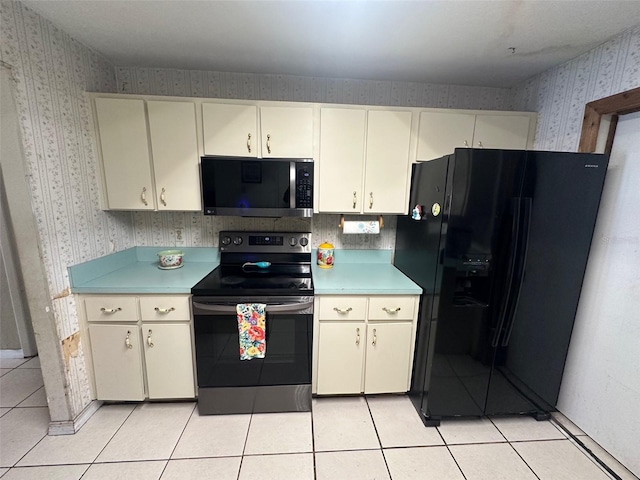 kitchen featuring cream cabinets, light tile patterned flooring, stainless steel appliances, light countertops, and wallpapered walls