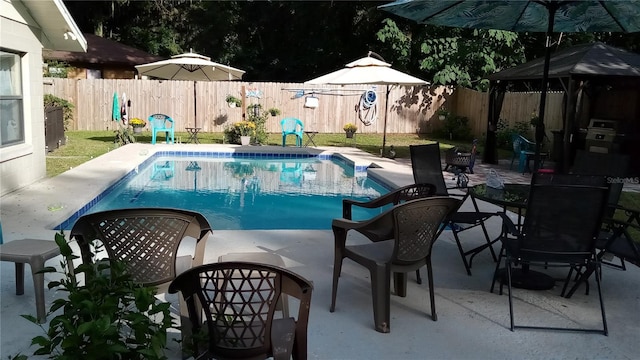 view of swimming pool featuring a patio, a gazebo, a fenced backyard, and a fenced in pool