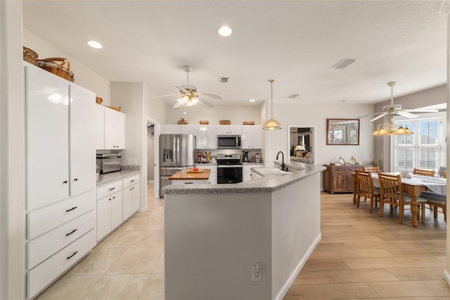 kitchen featuring appliances with stainless steel finishes, a sink, and white cabinets