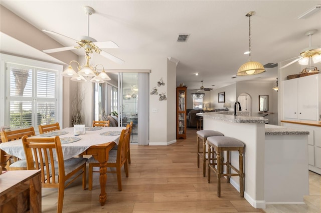 dining area with lofted ceiling, ceiling fan, visible vents, and light wood-style flooring